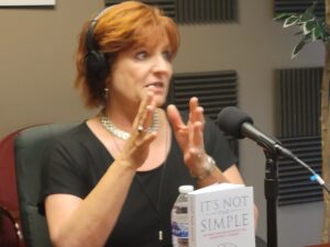 A woman wearing headphones and talking into a microphone.