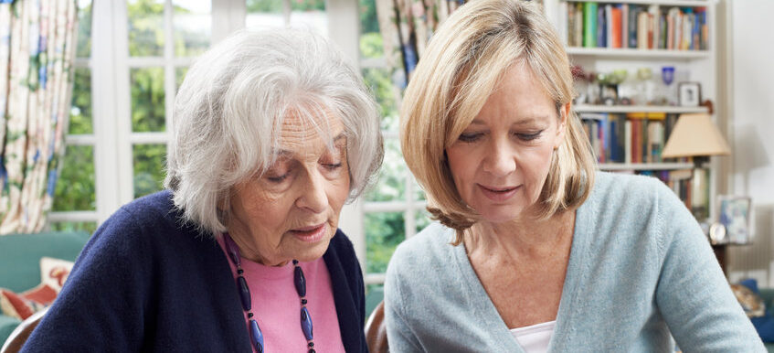 A woman and an older lady looking at each other.